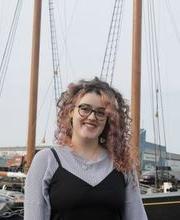 Carolyn King, '23, posing in front of a sailing ship